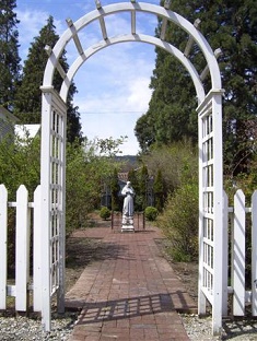 Entry arbor of the Old Rose Garden with St. Francis of Assisi in the background